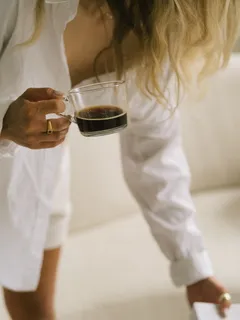Pessoa a segurar um copo de vinho tinto