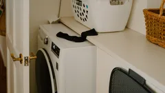 Máquina de lavar roupa branca com cesto de roupa e meia